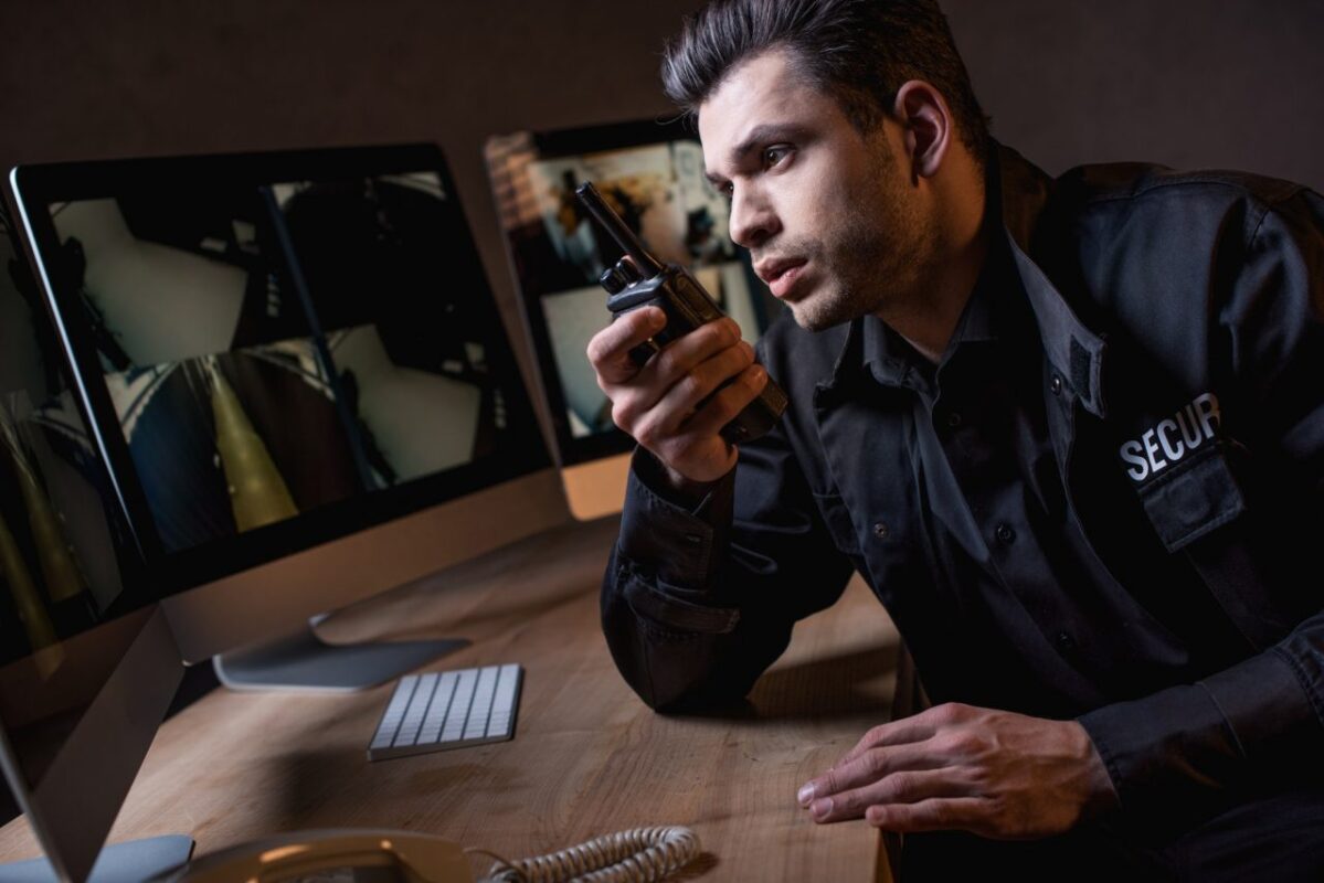 handsome-guard-in-uniform-talking-on-walkie-talkie-at-workplace